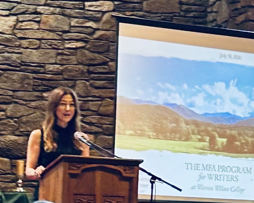Reading at a lectern for the MFA Program for Writers